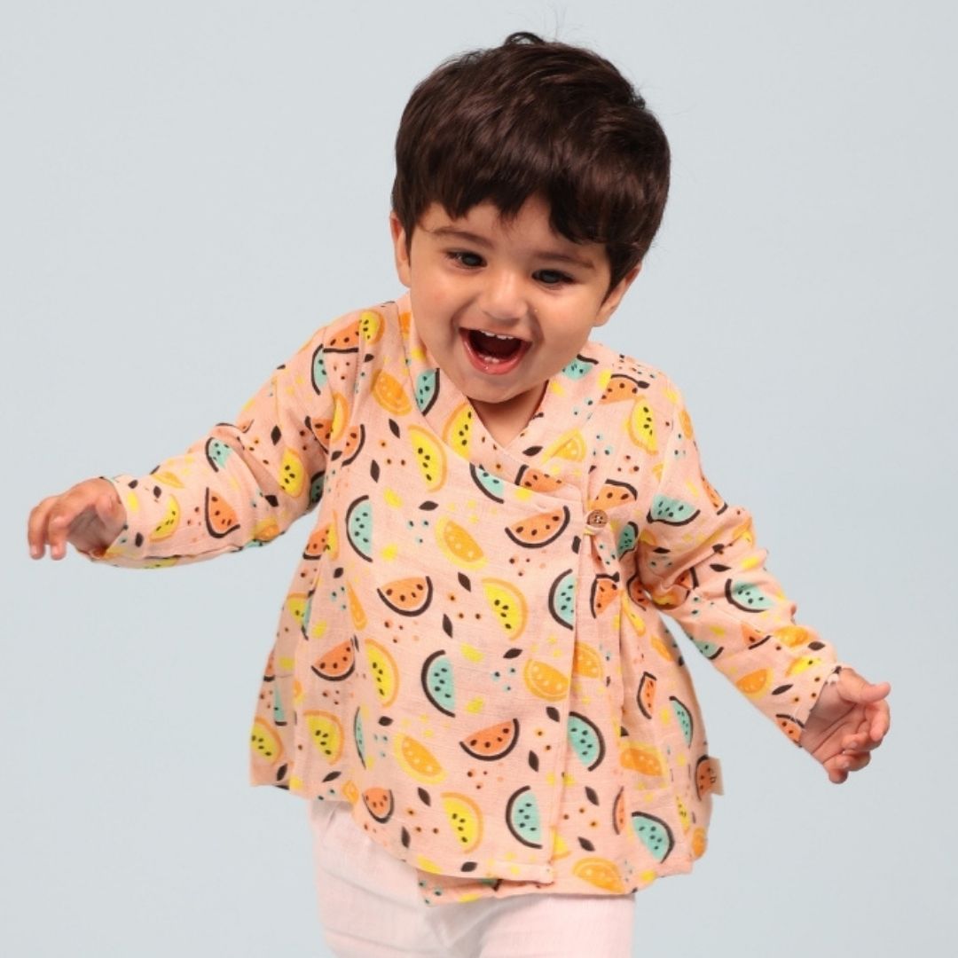 Vibrant Lemons Muslin Angrakha Set: A woman wears a flowing angrakha top and matching pants with a yellow lemon print.