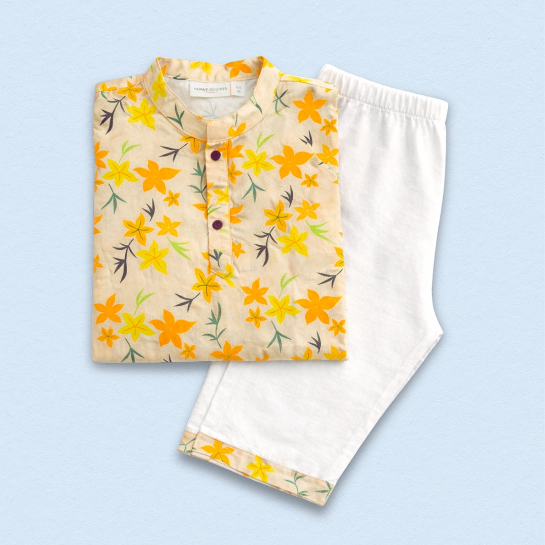 Summer Orange Floral Cotton Kurta Set: A woman models a vibrant orange cotton kurta with a floral print, paired with